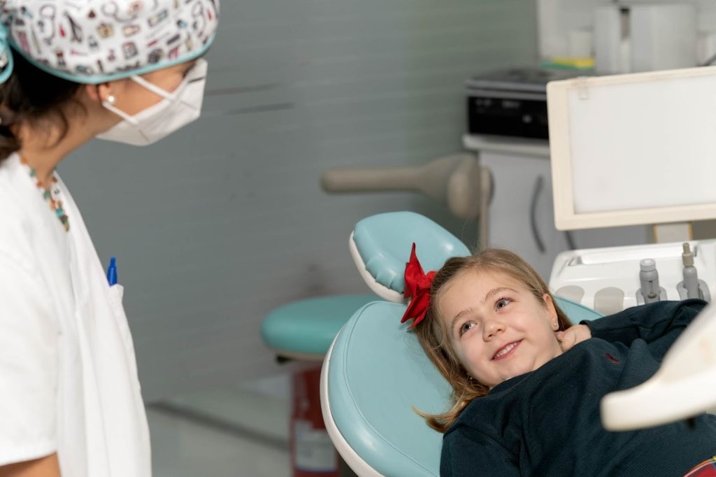 Revisión dental infantil en una clínica dental de Zaragoza de un diente de leche móvil y de caries blancas en la fase inicial del recambio dental.